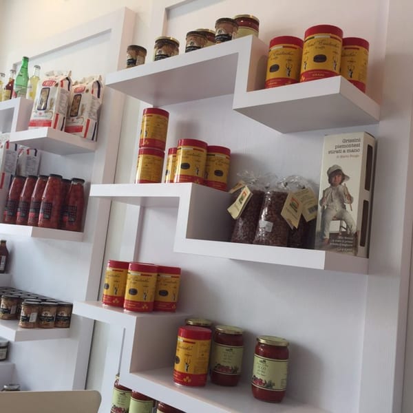 White shelves filled with various Italian food products like pasta, sauces, and canned goods.